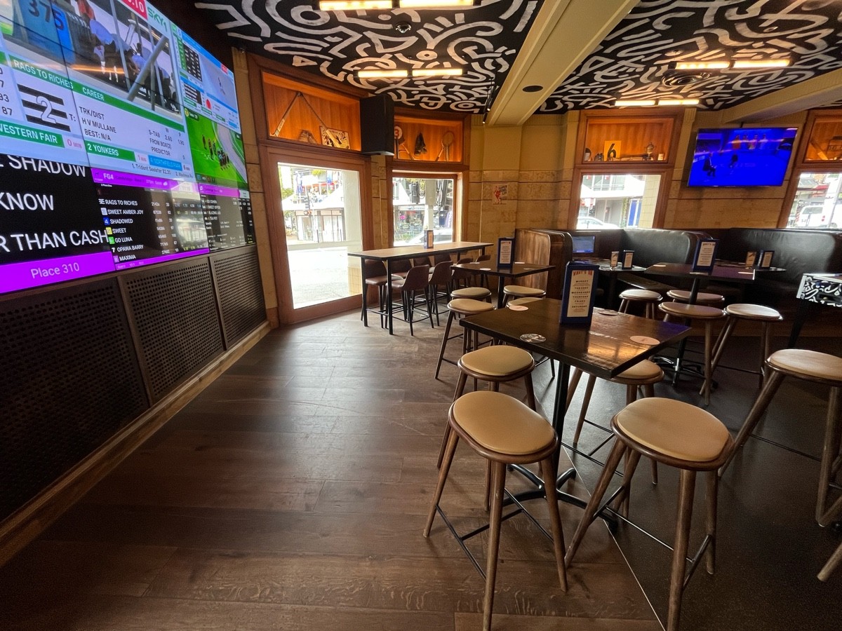 From entrance facing right. High tables and backed stools ahead to right. High tables and backless stools scattered to right.