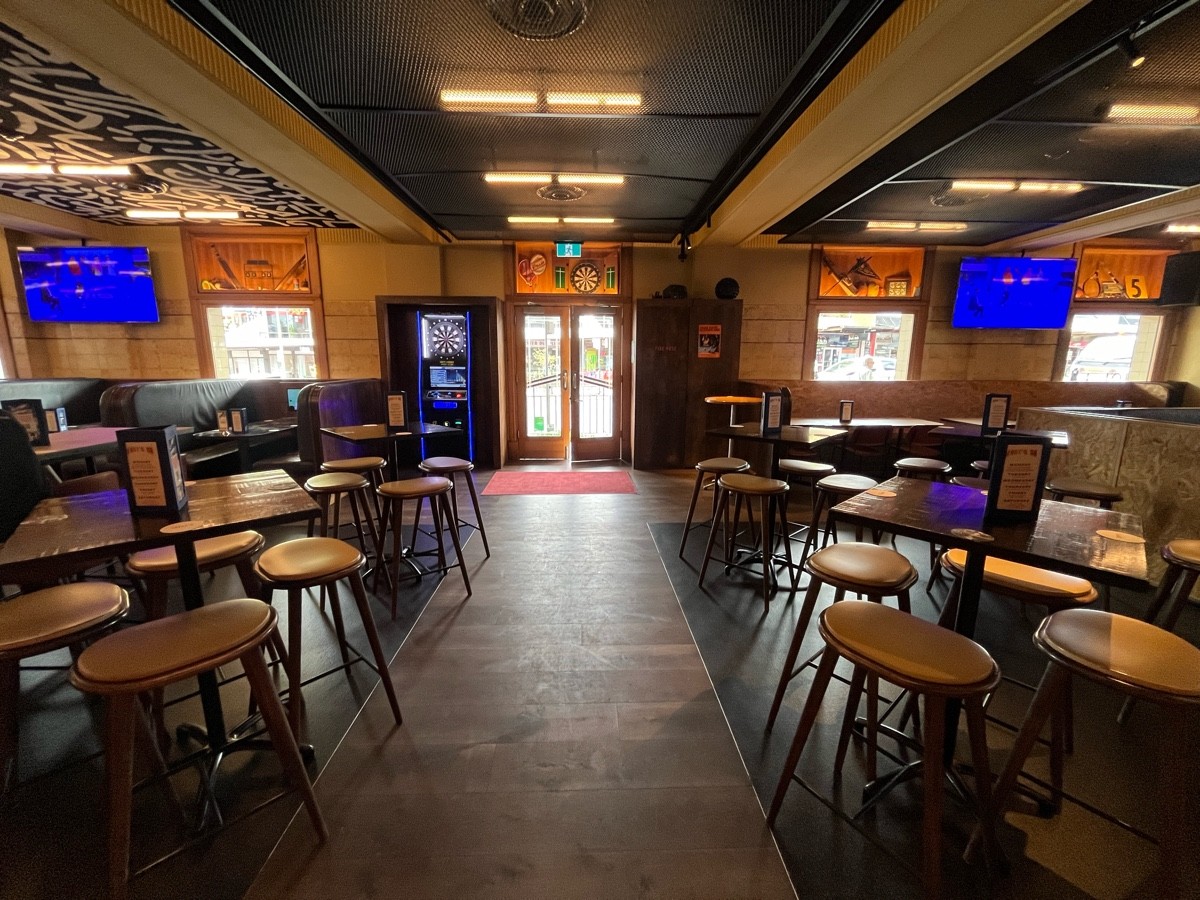 From after tables and backed stools facing left. Accessible entrance on wall directly ahead. High tables and backless stools either side.