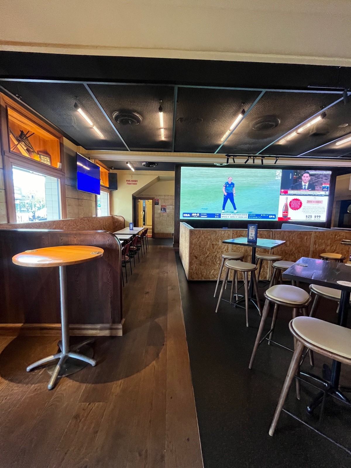 From accessible entrance facing left. Half booths along left ahead. High tables and stools scattered to right. Path to upstairs behind half booths.