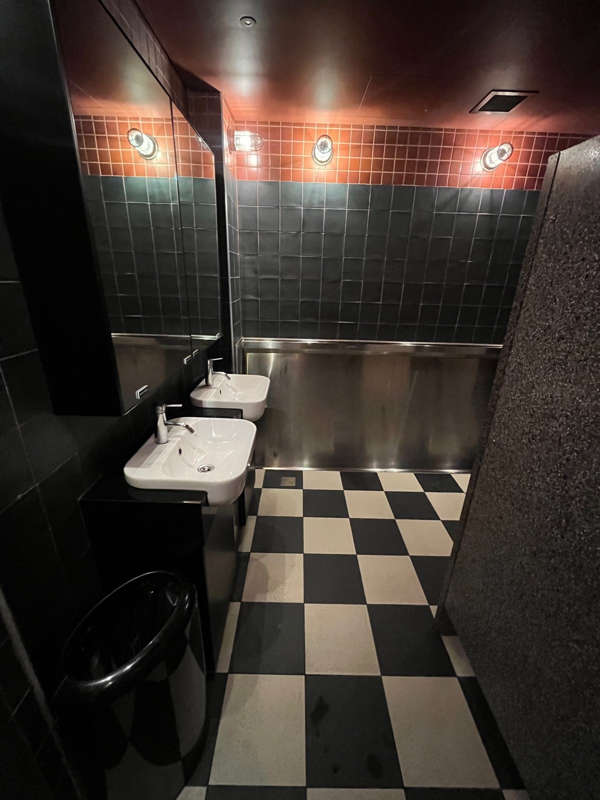 From door facing straight. Sinks on left wall. Urinals on wall ahead to right.