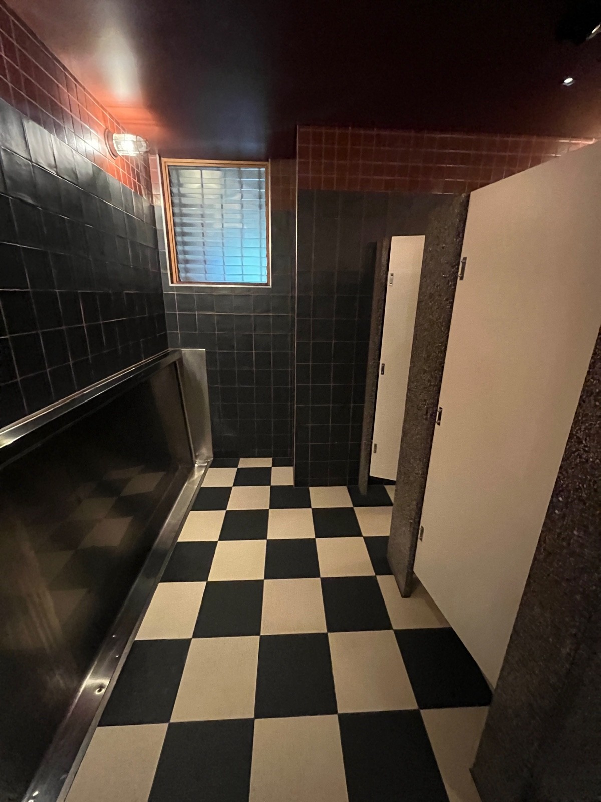From sinks facing right. Urinals on left wall. Cubicles on right wall.