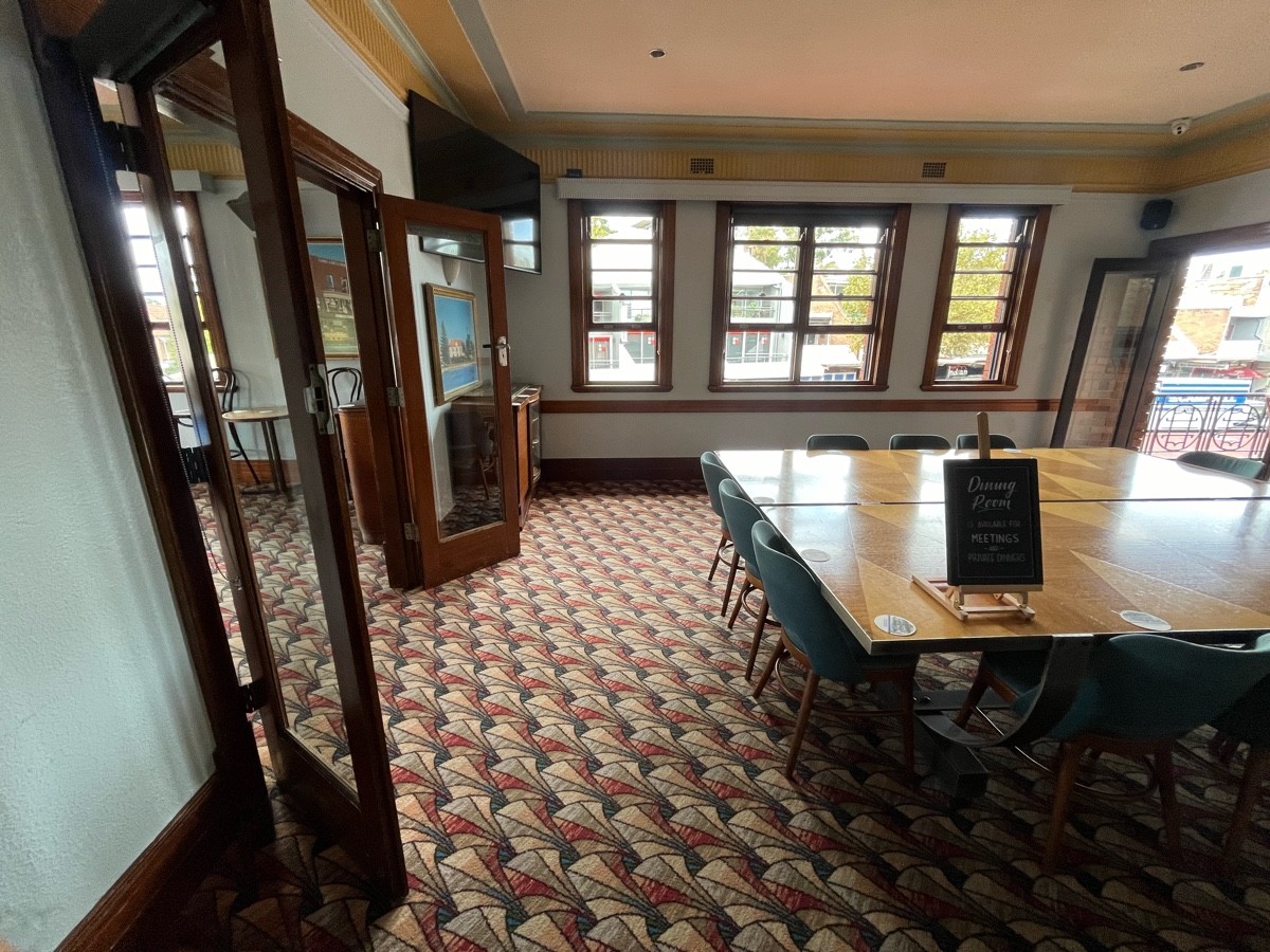 From doors facing straight. Large table with chairs to right. Doors to further seating on le