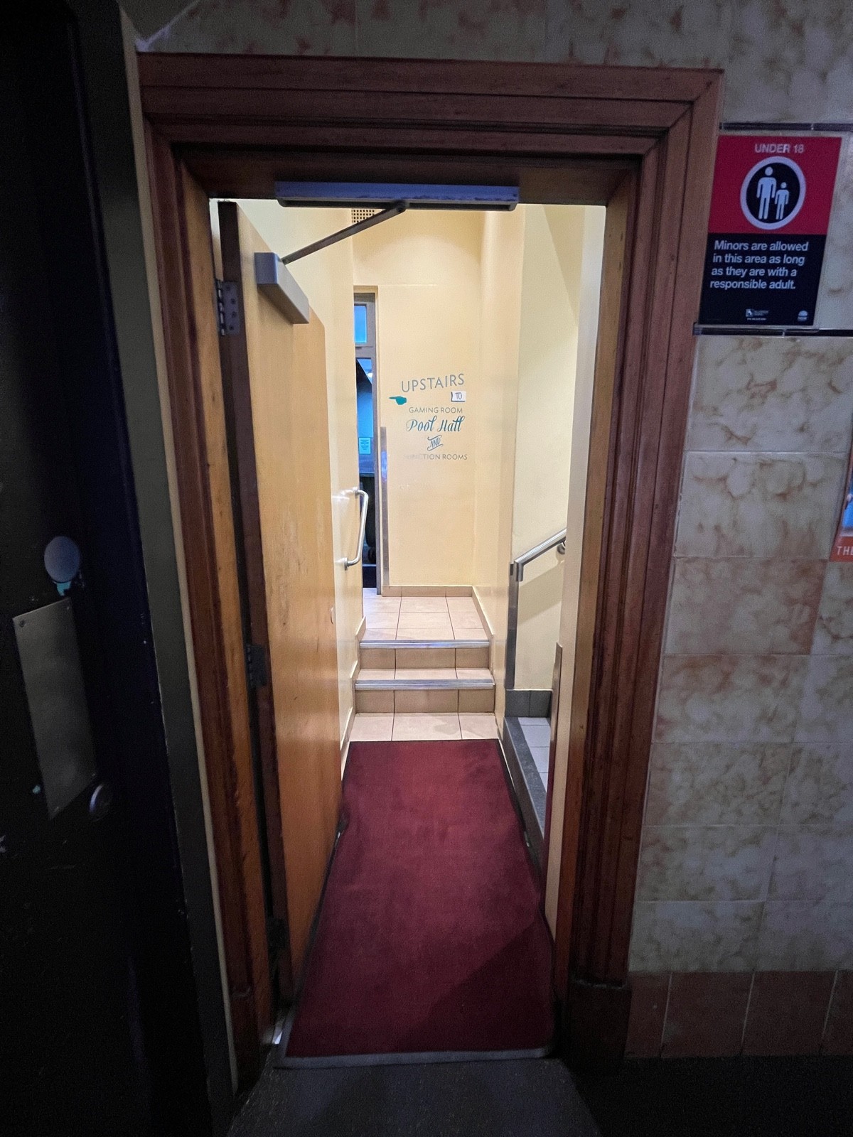 From after half booths facing straight. Brown wooden door. Push from right.