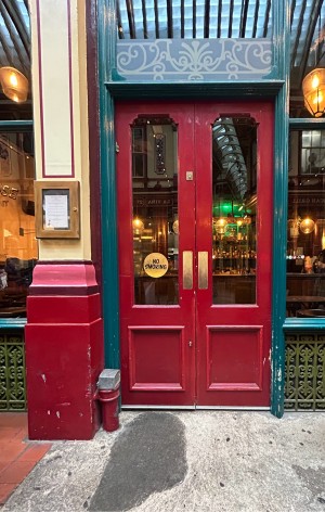 Red wooden doors with glass panels. Push from centre to open.