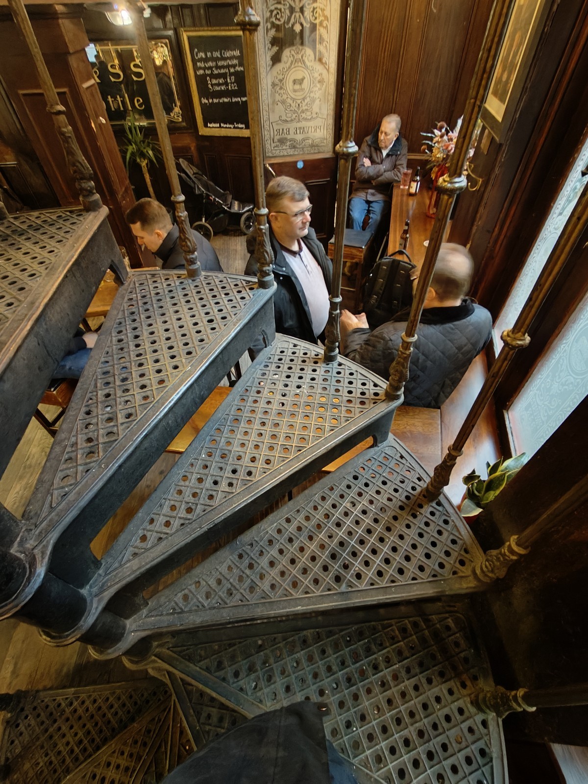 From first curve of stairs facing left. Stairs continue to curve ahead. Handrails on both sides.