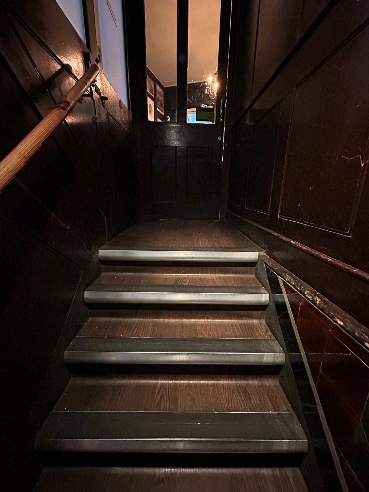 From end of second curve facing straight. Stairs ahead lead to doorway at back. Handrail on left.