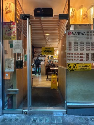 Clear glass door ahead. Push silver handle on left to open.