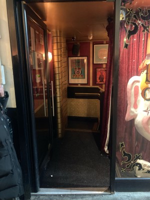 Glass door with black frame ahead. Push door to open from right.