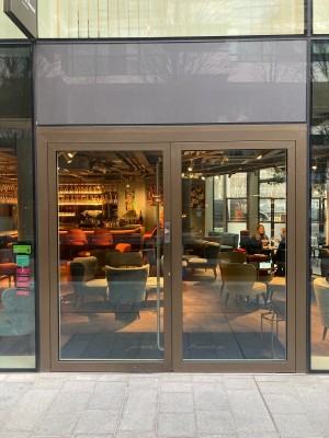 Glass doors with metal frame ahead. Push left door to open from center.