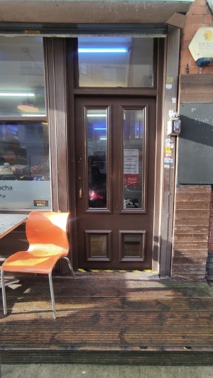 From pavement facing venue. One step up to platform. Door at the back.