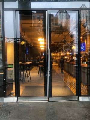 Glass door with black frame. Pull handle in centre to open.