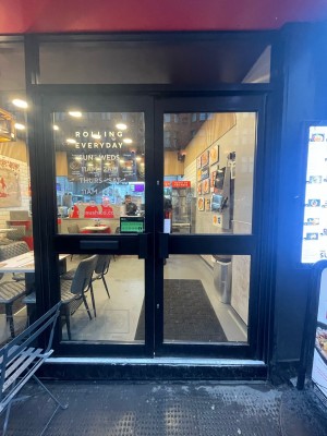 Glass doors with black frame ahead. Push black metal handles in centre to open.