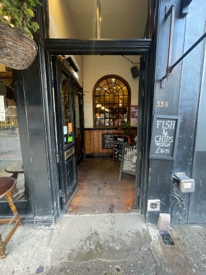 Black glass and wooden doors ahead. Push from centre to open.