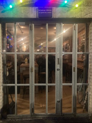 Glass door with white frame ahead. Pull door to open via handle on right.