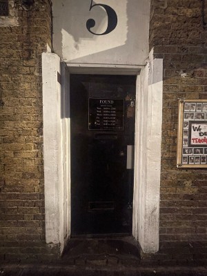 Black wooden door ahead. Push from right to open.