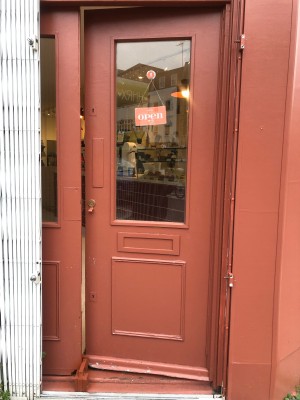 Pink door with glass panel. Push from left to open.