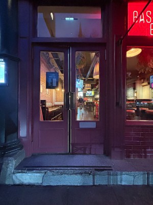 Red wooden doors with glass panels ahead. Push from centre to open.