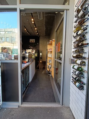 Glass door with silver frame. Push silver handle on left to open.