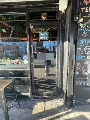 Single glass door with black metal frame. Push sliver handle on left to open.
