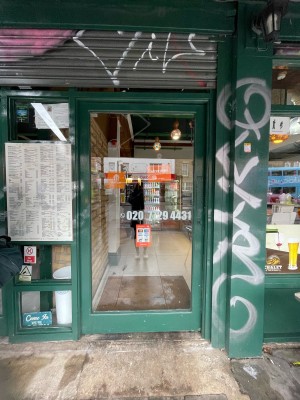 Single glass door with green frame. Push on right.