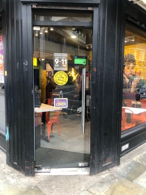 Glass door ahead. Push silver metal handle on right to open.