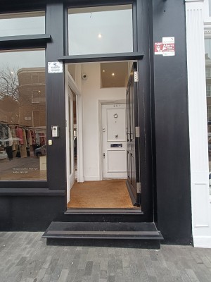 Black wooden door with silver handle on middle. Push from left to open.