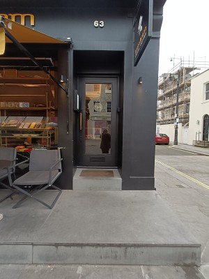 From street, facing venue. One step up to seating and doorway.