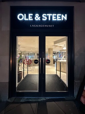 Glass doors with black frame. Push handles in centre to open.