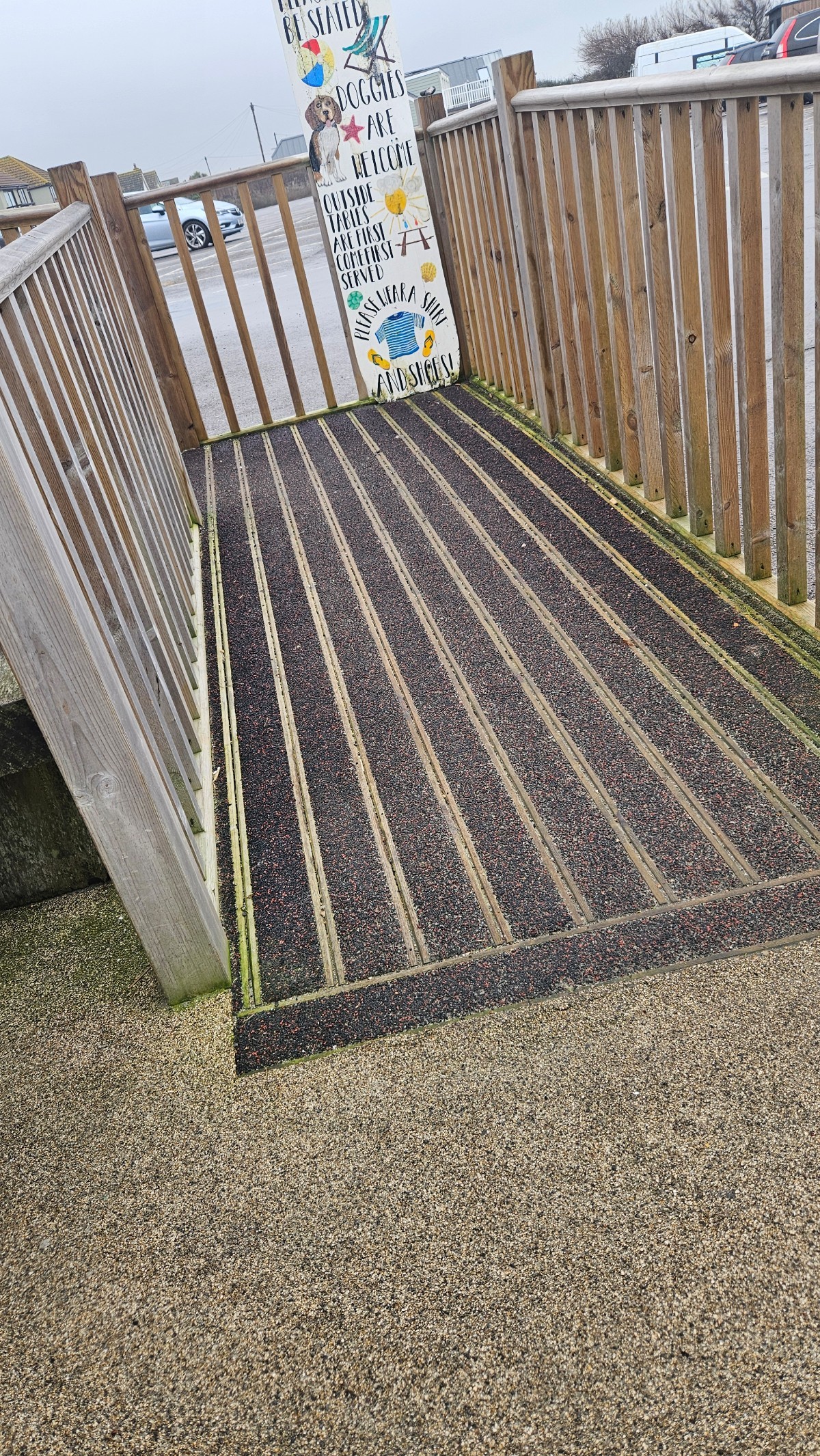 A black textured ramp with wooden handrails