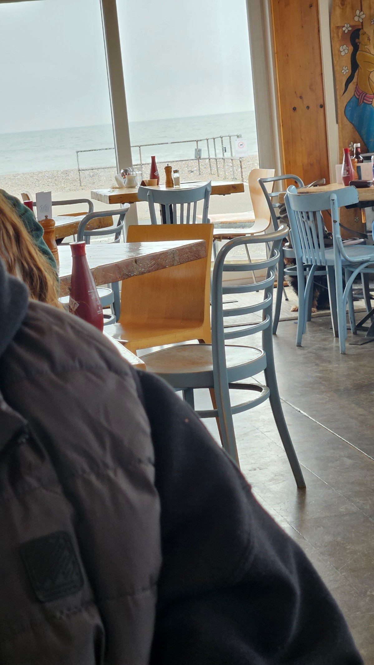 A close up of tables in the cafe. A sea view through the window