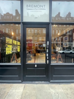 Black and glass panelled door. Push from right to open. Black doorbell to top right of door