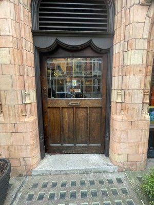 Brown glass and wooden door ahead. Push from left to open.