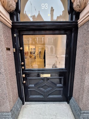 Black door with glass panel ahead. Push on left to open. Built in ramp before door.
