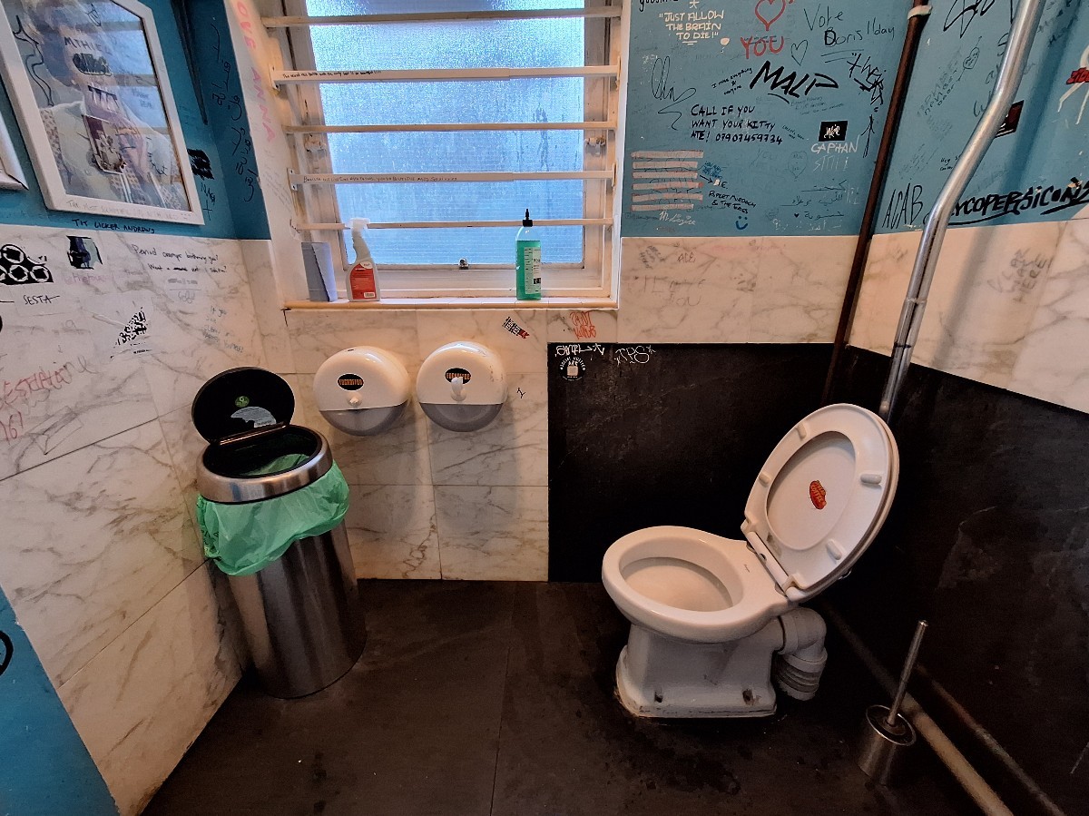 From door facing left. Bin on back left. Toilet on back right.