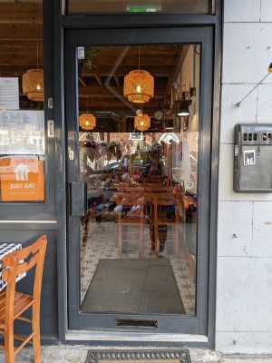 Glass door with black frame ahead. Push door to open from left.