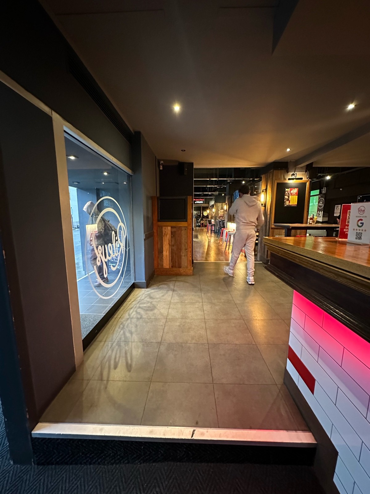 From archway facing left. Opening ahead. Bar to right.