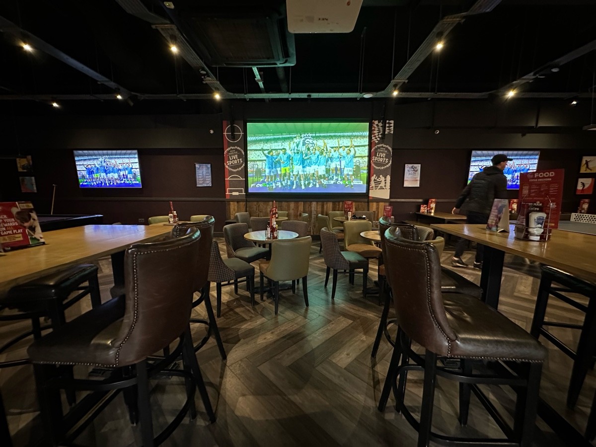 From pool table facing right. High tables and stools to left and right. Tables and chairs along back.
