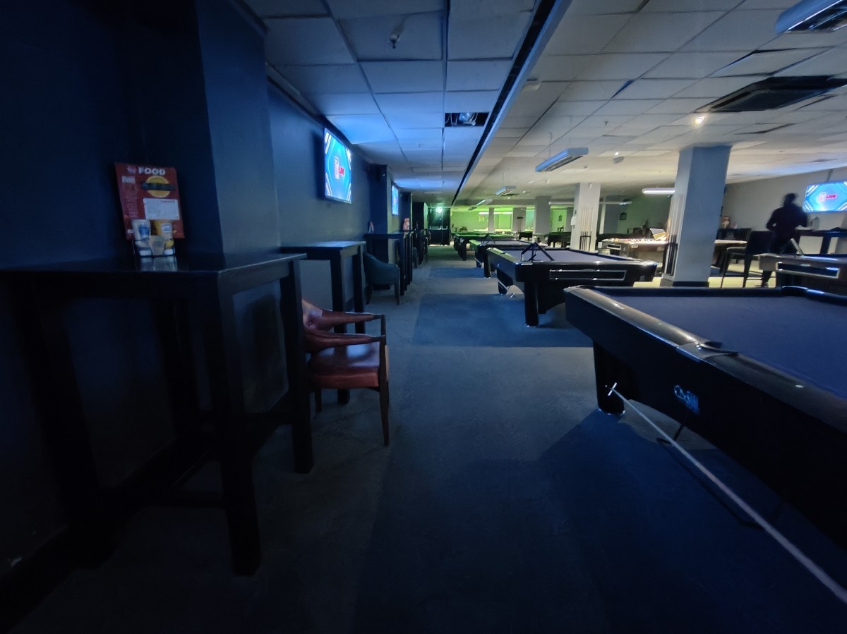 From high table facing right. Stools along left. Path ahead to pool tables at far back and on right.