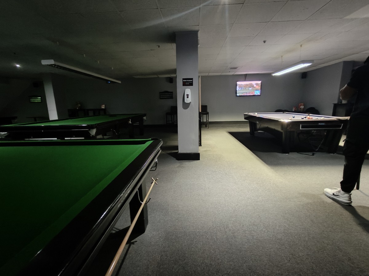 From between stools facing right. Pool tables on either sides. Column at back. Stool behind.