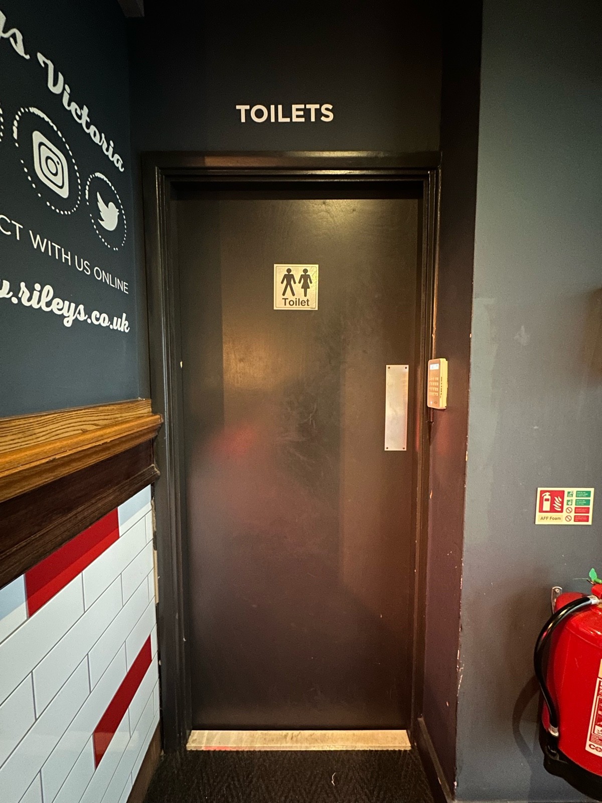 From entrance facing right. Black wooden preceding door ahead. Push from right to open.