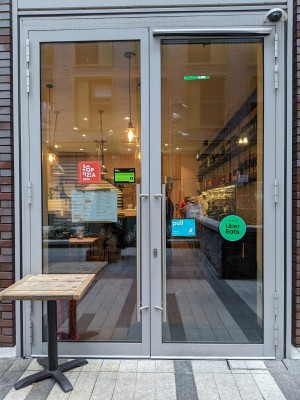 Glass doors with metal frame and metal handles. Table before left door. Pull from centre to open.