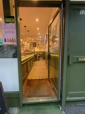 Green framed glass door. Push green handle on left to open.