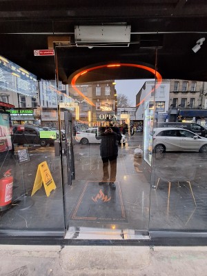 Glass door ahead. Push on metal handle on left to open. One step up at foot of door.