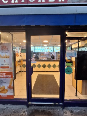 Glass door with blue frames. Push on left to open.