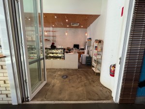 Glass doors with white metal frame fold open to left.