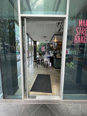 Glass door with grey metal frame. Push from right.