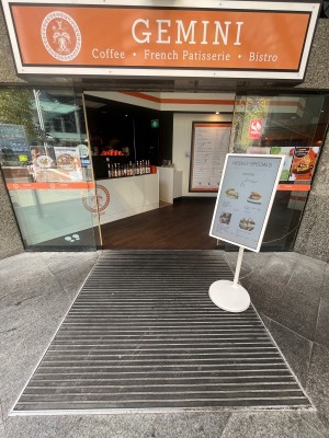 Glass doors slide open from middle. Signage obstructing to right.