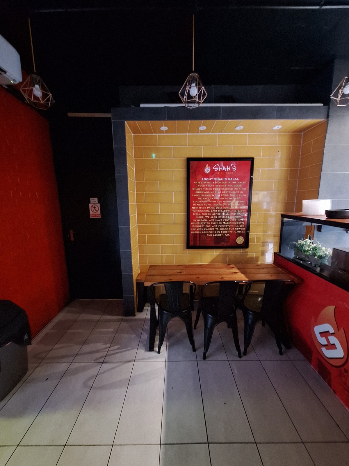 From counter facing left. Half booth with chairs on back right. Counter on right.