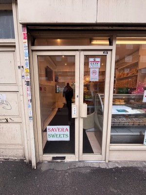 Glass doors with white doorframe ahead. Push metal handle at center to open.