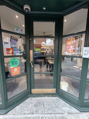 Green framed glass door. Push golden handle on left to open.